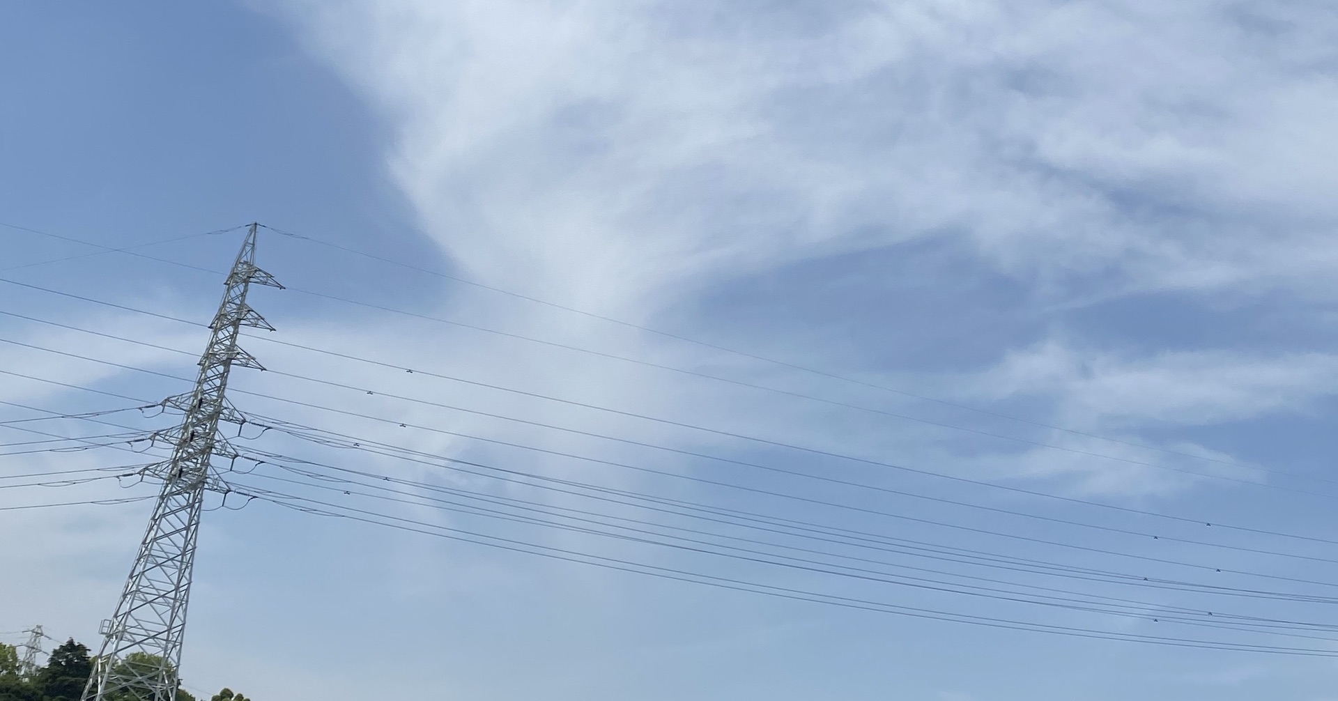 空をバックに立つ鉄塔の写真